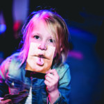 zdjęcie przedstawiające dziecko trzymające zdjęcie ust które przykłada do swoich ust