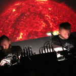Zdjęcie przedstawia duet muzyczny "Voices of the Cosmos" podczas koncertu
