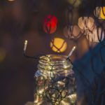 Zdjęcie przedstawia słoik wypełniony świecącym sznurem lampek