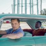 Kadr z filmu "Green Book" na którym widać dwóch mężczyzn siedzących w turkusowym samochodzie