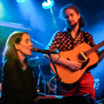 zdjęcie zespołu Retrospektakl wokalistka siedzi przy mikrofonie i śpiewa obok niej mężczyzna grający na gitarze