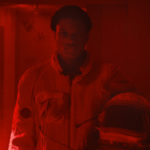 zdjęcie z filmu "Gagarine" - czarnoskóry bohater w stroju astronauty trzyma hełm