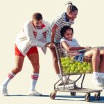zdjęcie z filmu "King Richard: zwycięska rodzina" grający główną rolę Will Smith pha swoje córki na wózku sklepowym wypełnionym piłkami tenisowymi