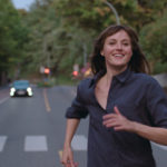 Kadr z filmu przedstawiający biegnącą po ulicy szczęśliwą kobietę