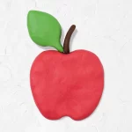 Zdjęcie przedstawia wykonane z plasteliny jabłko w kolorze czerwonym