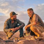 zdjęcie dwóch mężczyzn siedzących na pustyni