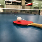 zdjęcie paletki i piłeczki na stole do tenisa stołowego