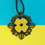 medalion haftowany na niebiesko-żółtym tle