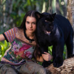 Na zdjęciu dziewczynka i czarny jaguar